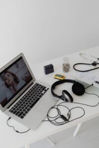 A clean white desk setup with a laptop, headphones, and various office items for remote work.